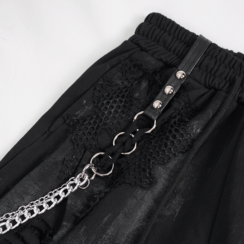 Close-up of gothic women's black cargo pants featuring elastic waist, chains, and rivets for a trendy look.