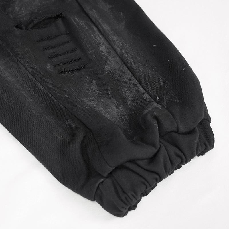 Close-up of black elastic waist cargo pants showcasing distressed details and gathered cuffs for a trendy gothic look.