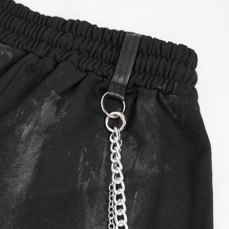 Close-up of black elastic waist cargo pants with chain and rivet details, perfect for gothic fashion.