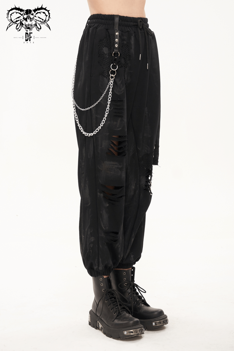 Gothic women's black cargo pants with elastic waist, metal chains, and rivets, paired with black combat boots.