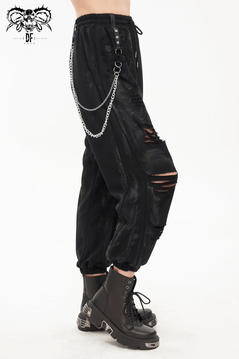Gothic women's black cargo pants with elastic waist, chains, and rivets, styled with chunky black boots.