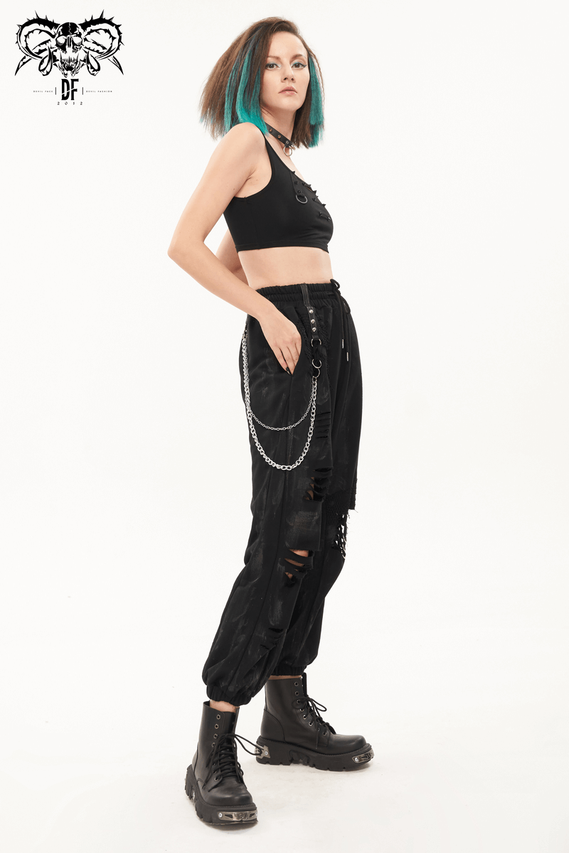 Gothic women's black cargo pants with chains and rivets, styled with a cropped top and edgy boots.