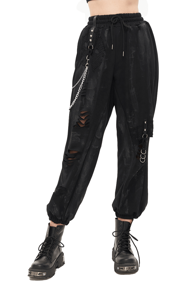 Gothic women's black cargo pants with elastic waist, chains, and rivets, styled with trendy black combat boots.