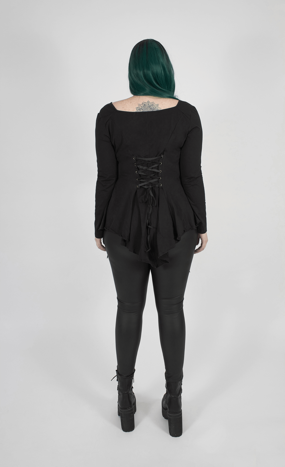 Back view of a woman in a Gothic lace-up flared sleeve top and black leggings, showcasing elegance and comfort.