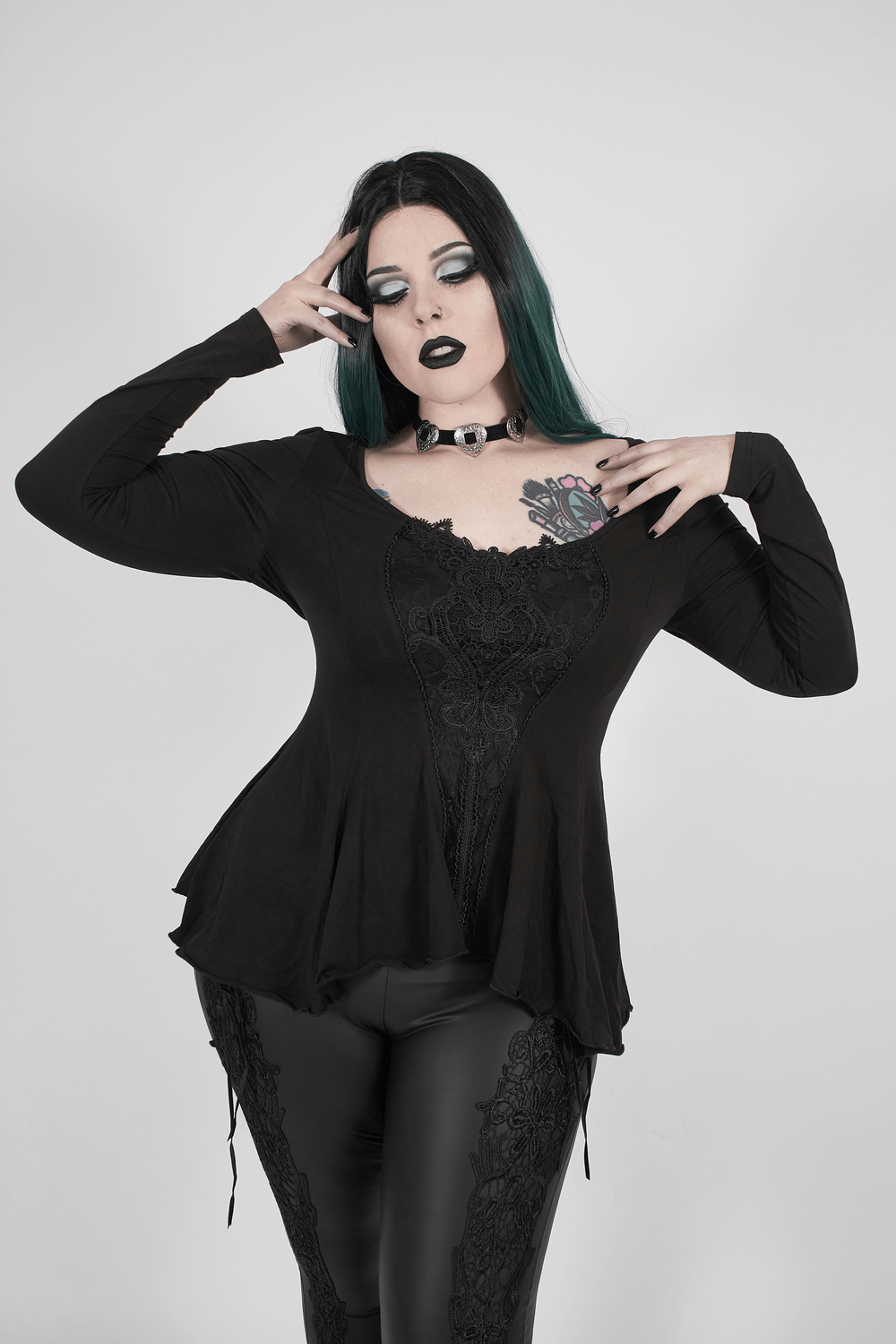 Gothic women's fitted top with lace accents and flared sleeves, paired with stylish black leggings and bold accessories.