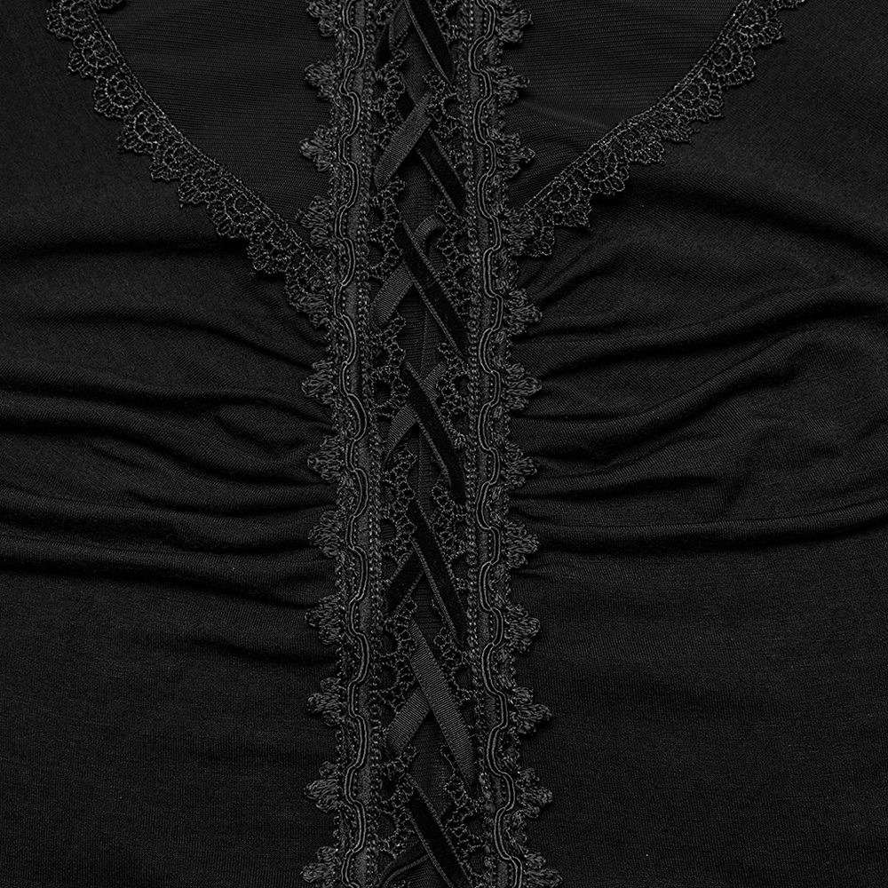 Close-up of gothic women's dress lace detailing and ribbon accents on black fabric.
