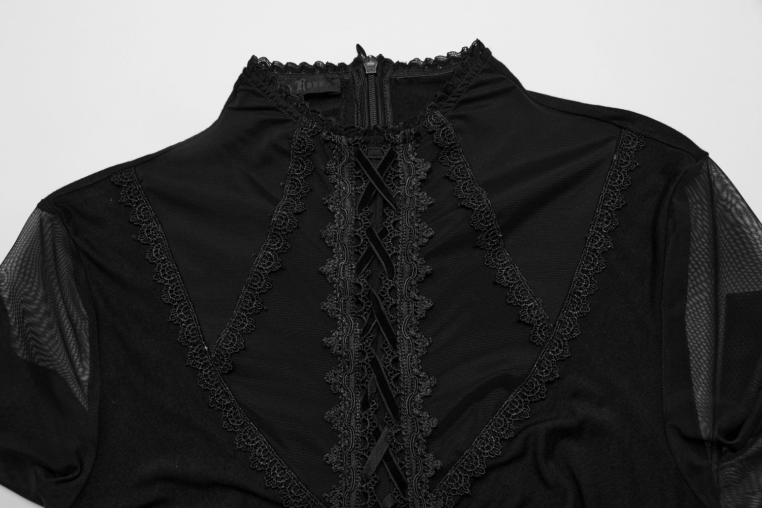 Close-up of Gothic women's dress with lace details and mesh sleeves, showcasing elegant black fabric and intricate design.