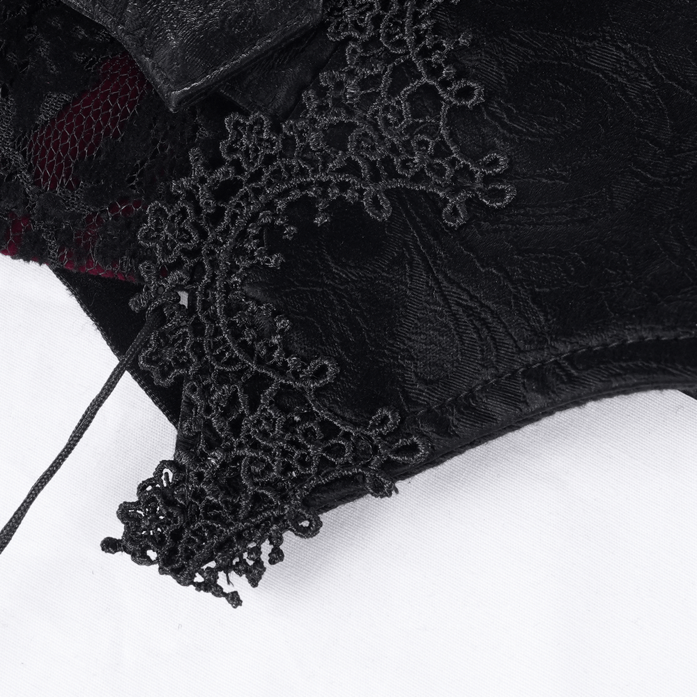 Close-up of intricate black lace and tassel detailing on a gothic women's corset belt.