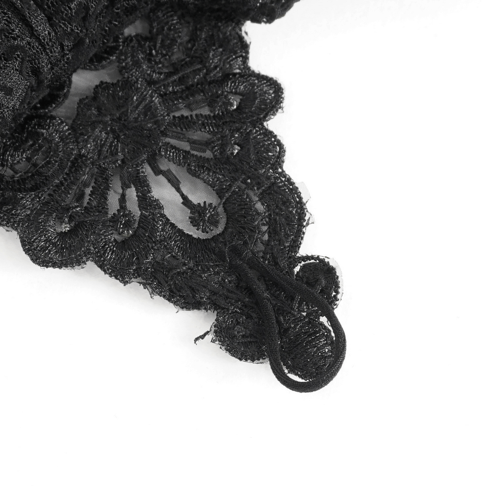 Close-up of intricate black lace detail on Gothic fingerless gloves with elegant textures.