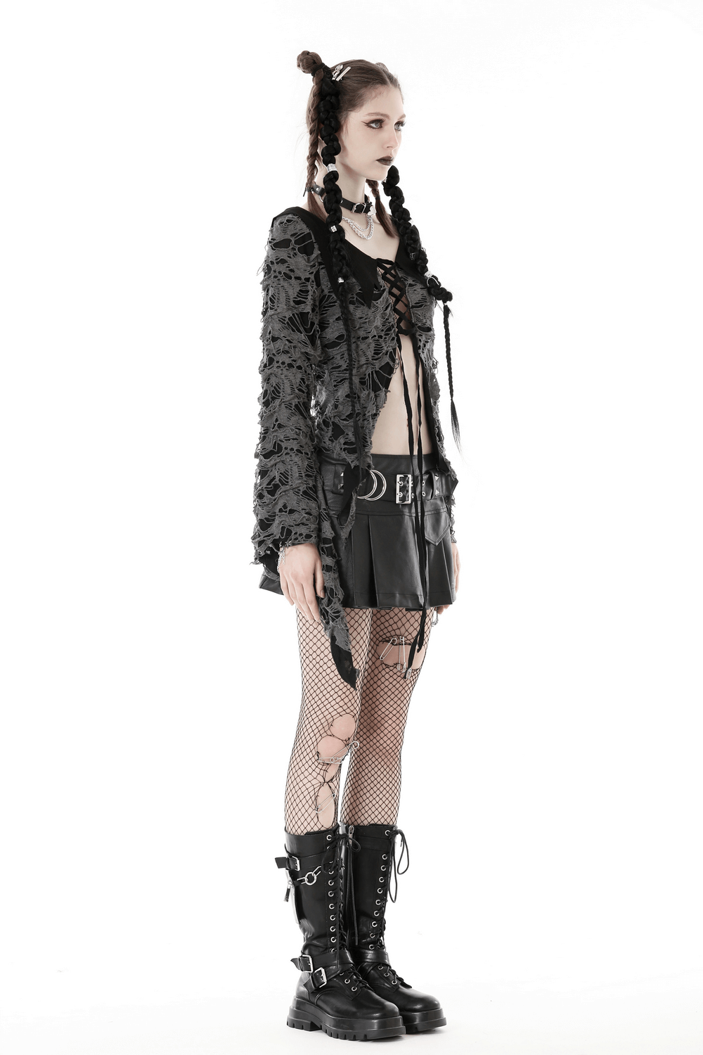 Gothic women's lace-up shredded top with dramatic bell sleeves, paired with a black skirt and combat boots.