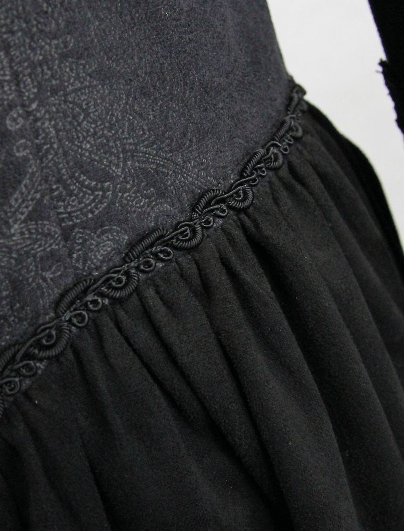 Elegant close-up of the intricate lace design on a gothic women's long black coat.