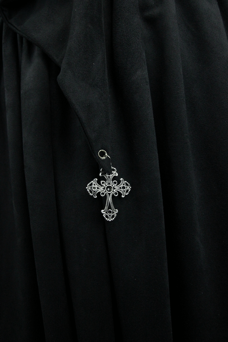 Close-up of a gothic-style black coat with a decorative silver cross pendant.