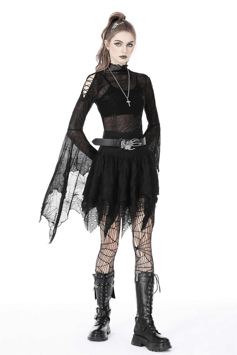 Gothic woman in a black mesh spiderweb top and skirt, showcasing edgy style with long sleeves and fishnet tights.