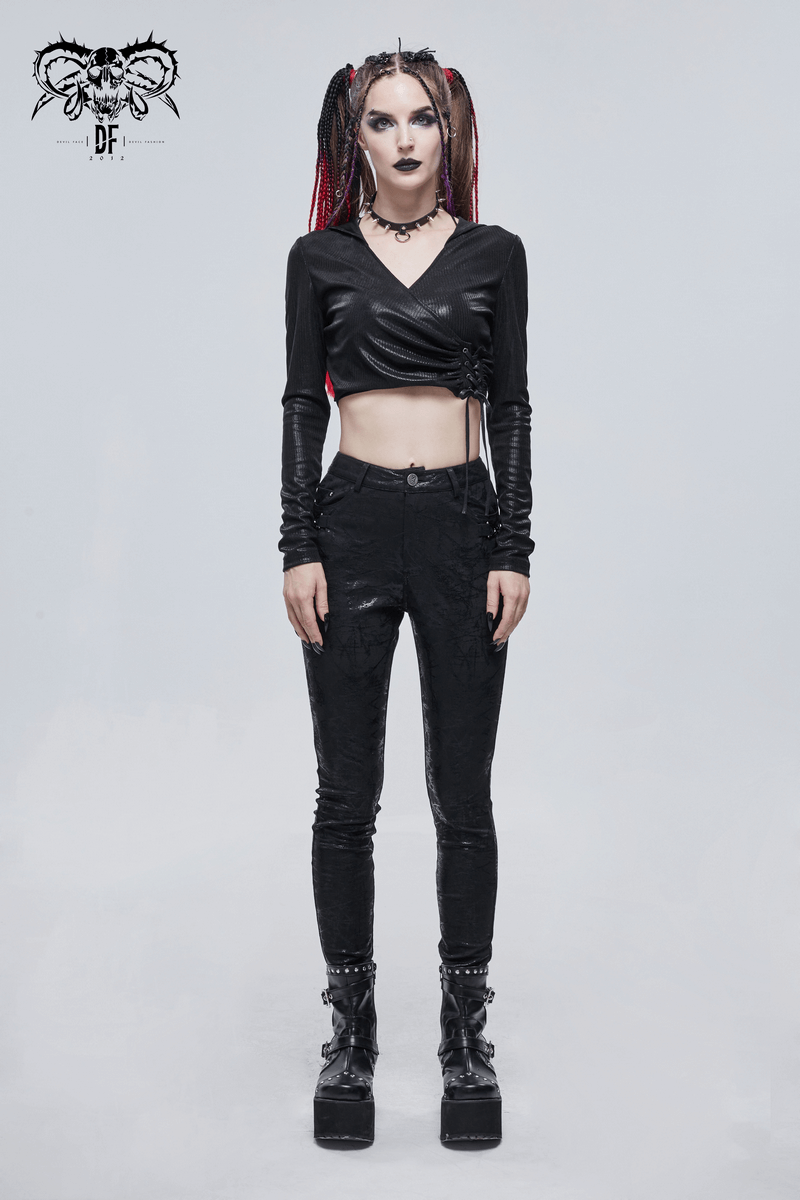 Gothic women's slim-fitted black pants with buckle accents paired with a stylish cropped top and edgy platform boots.