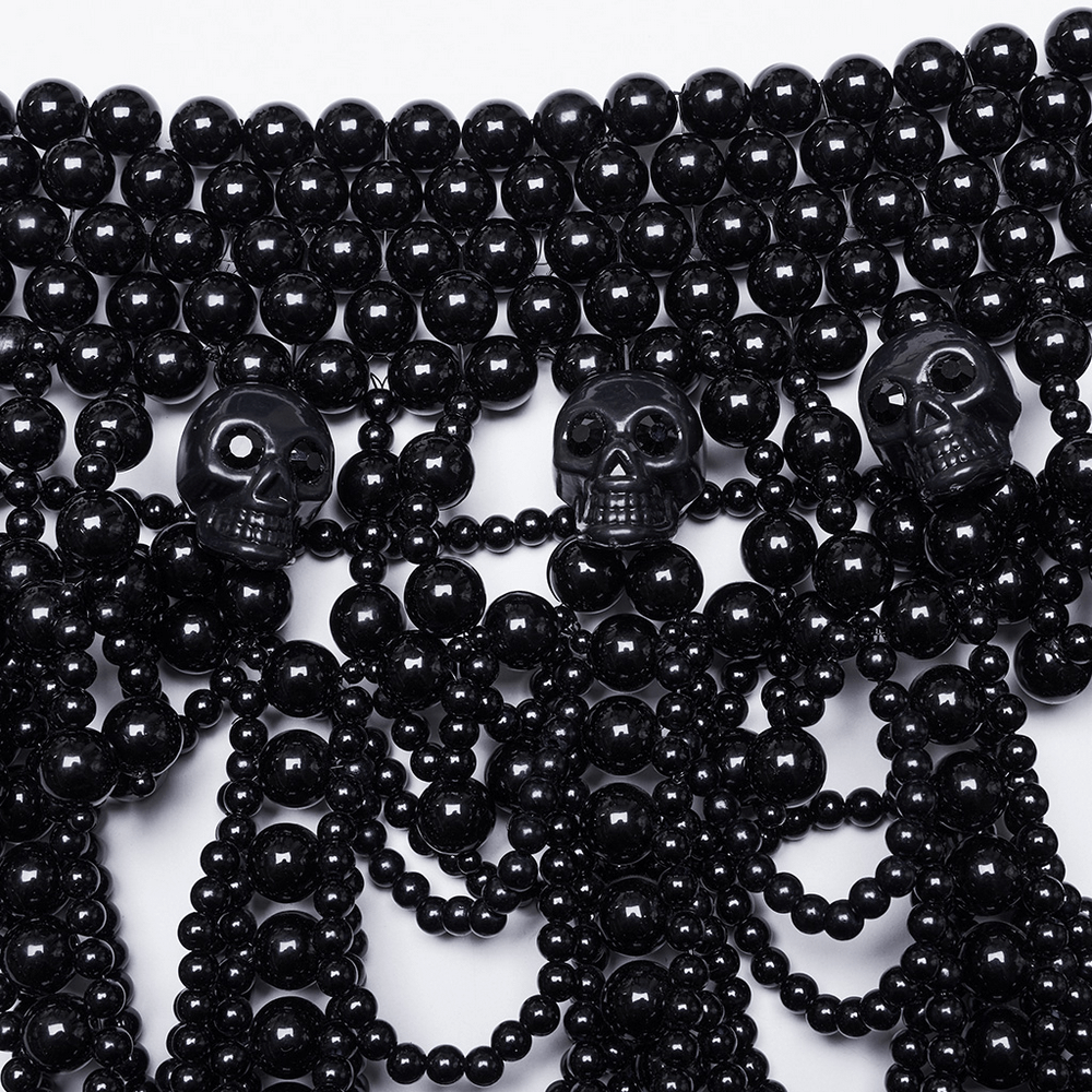 Gothic black beaded skull body accessory with pearl strands, showcasing chic skull accents for a bold fashion statement.