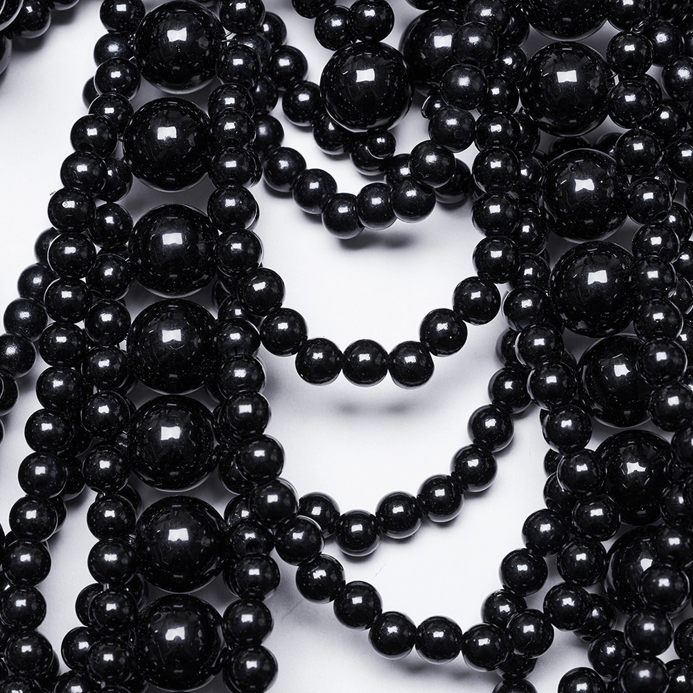 Close-up of elegant black beaded gothic accessory with pearl-like texture, showcasing intricate design and sophistication.