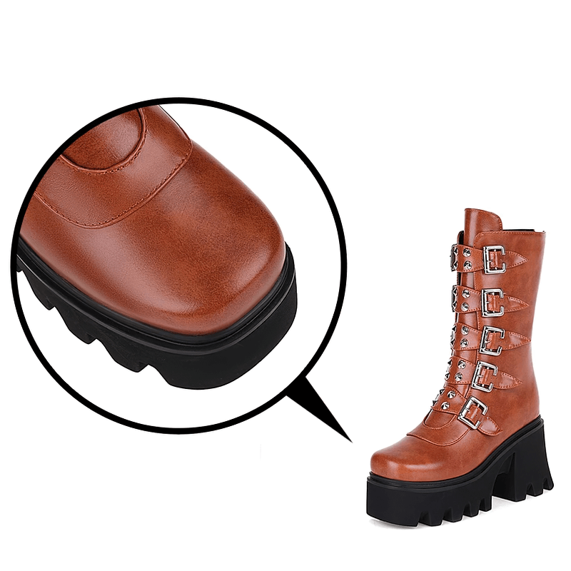 Close-up of gothic mid-calf platform boots with buckle straps and chunky sole in brown imitation leather.