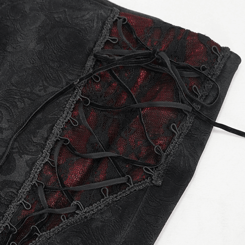 Close-up of black gothic PU leather pants showcasing red lace insert and stylish lace-up detailing.