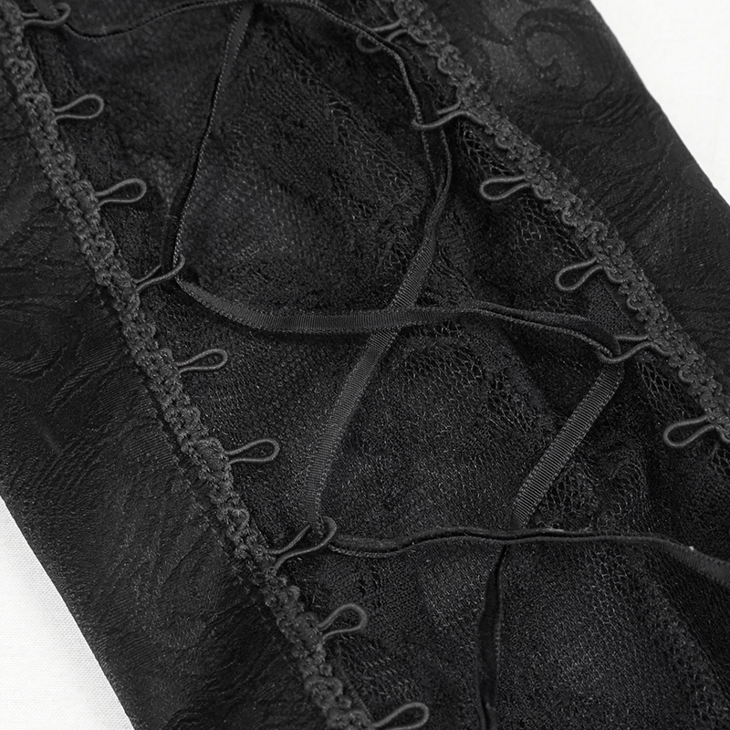Close-up of black lace insert with decorative lace-up details on gothic style pants.