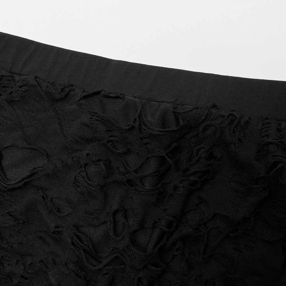 Close-up of gothic women's ripped flare pants showcasing ragged texture and elastic fabric.