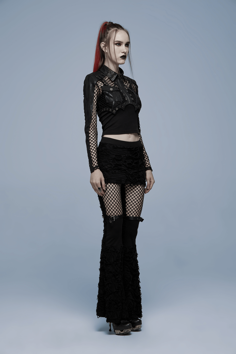 Gothic women's ripped flare pants with mesh detailing, styled with a black crop top for an edgy look.