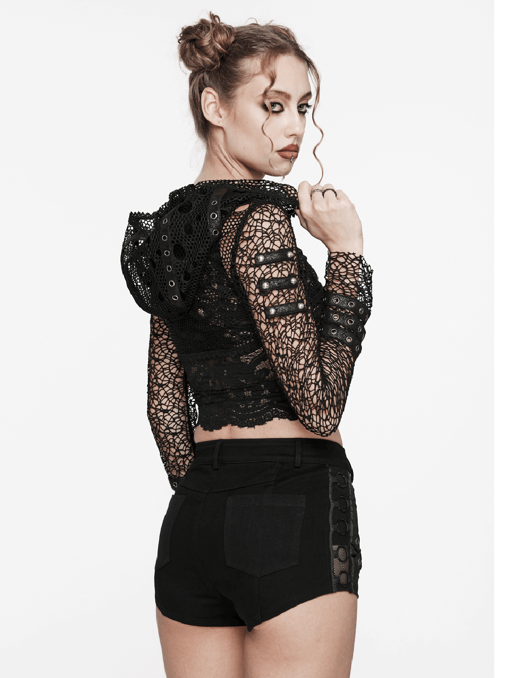 Gothic women's cropped hoodie with mesh sleeves and lace detail, worn with stylish black shorts.