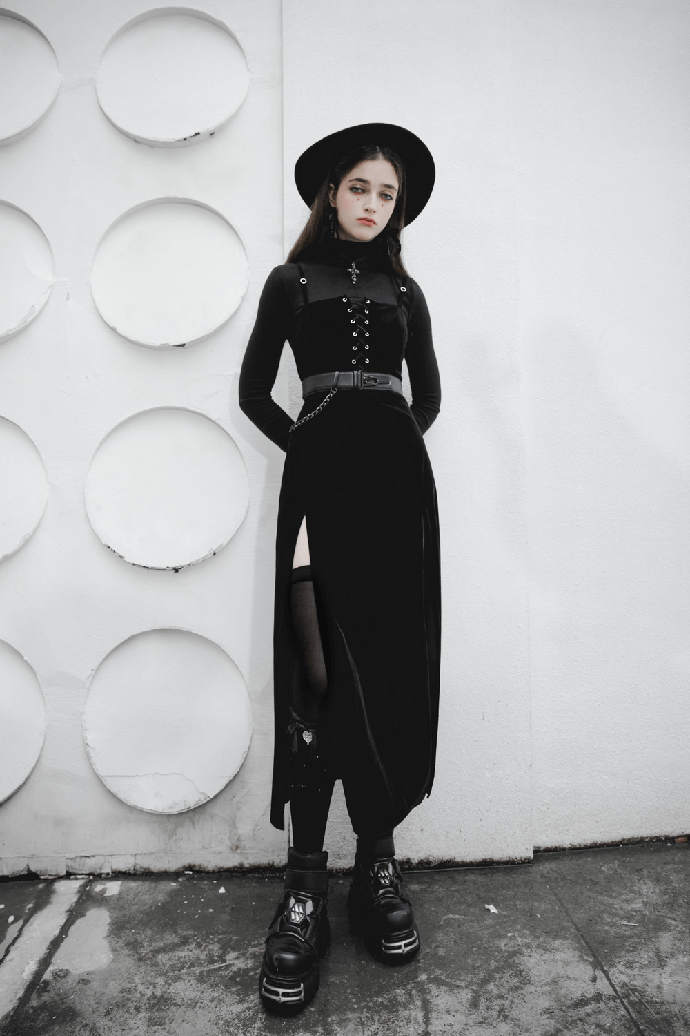 Gothic women's velvet long dress with suspenders, styled with a vintage hat and chunky platform boots, ready to make a statement.