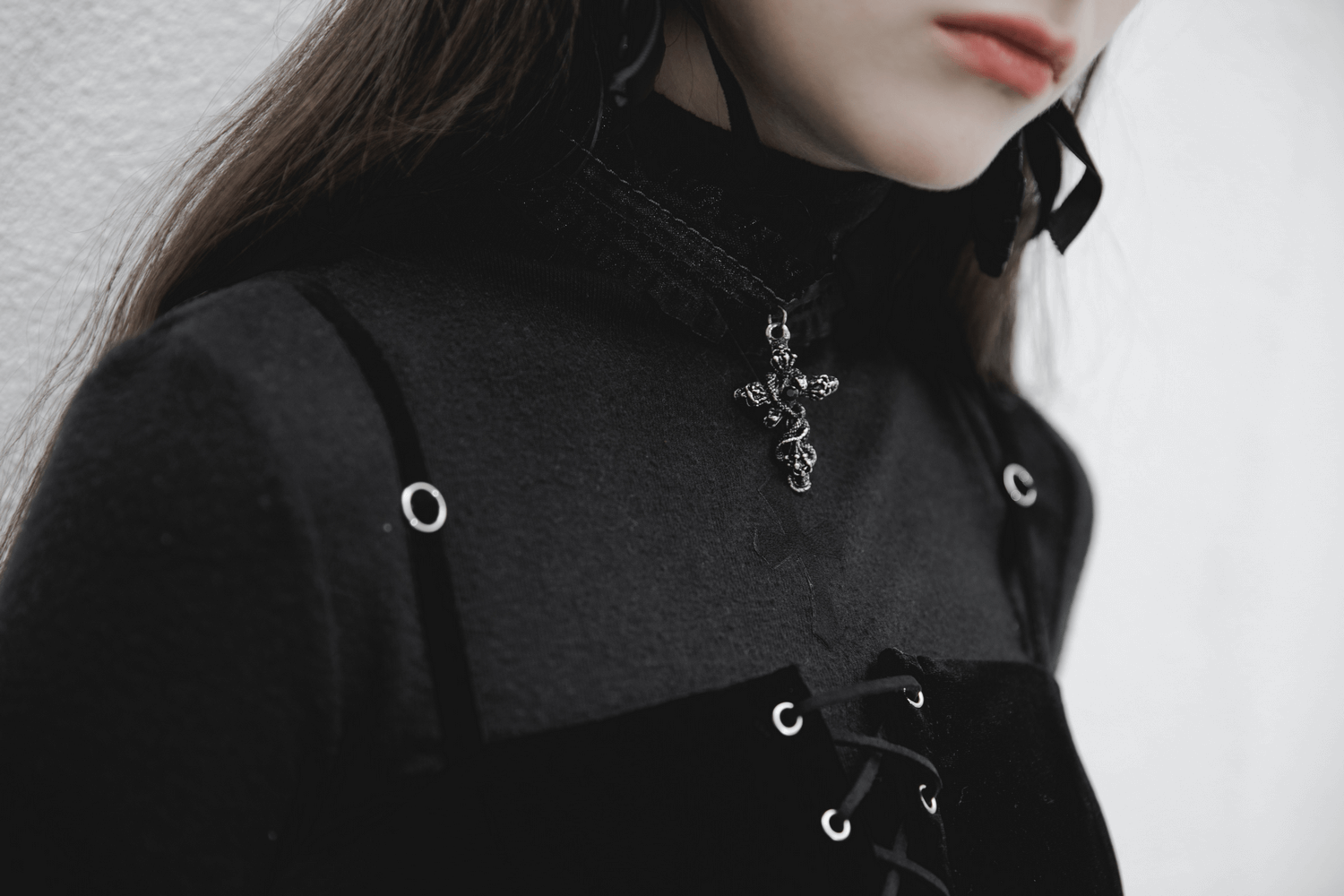 Close-up of a Gothic velvet suspender dress with intricate detailing and a stylish pendant.