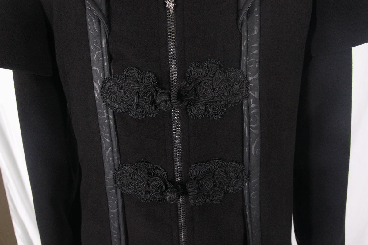 Close-up of a gothic black trench coat featuring intricate black floral designs and a sturdy zipper.