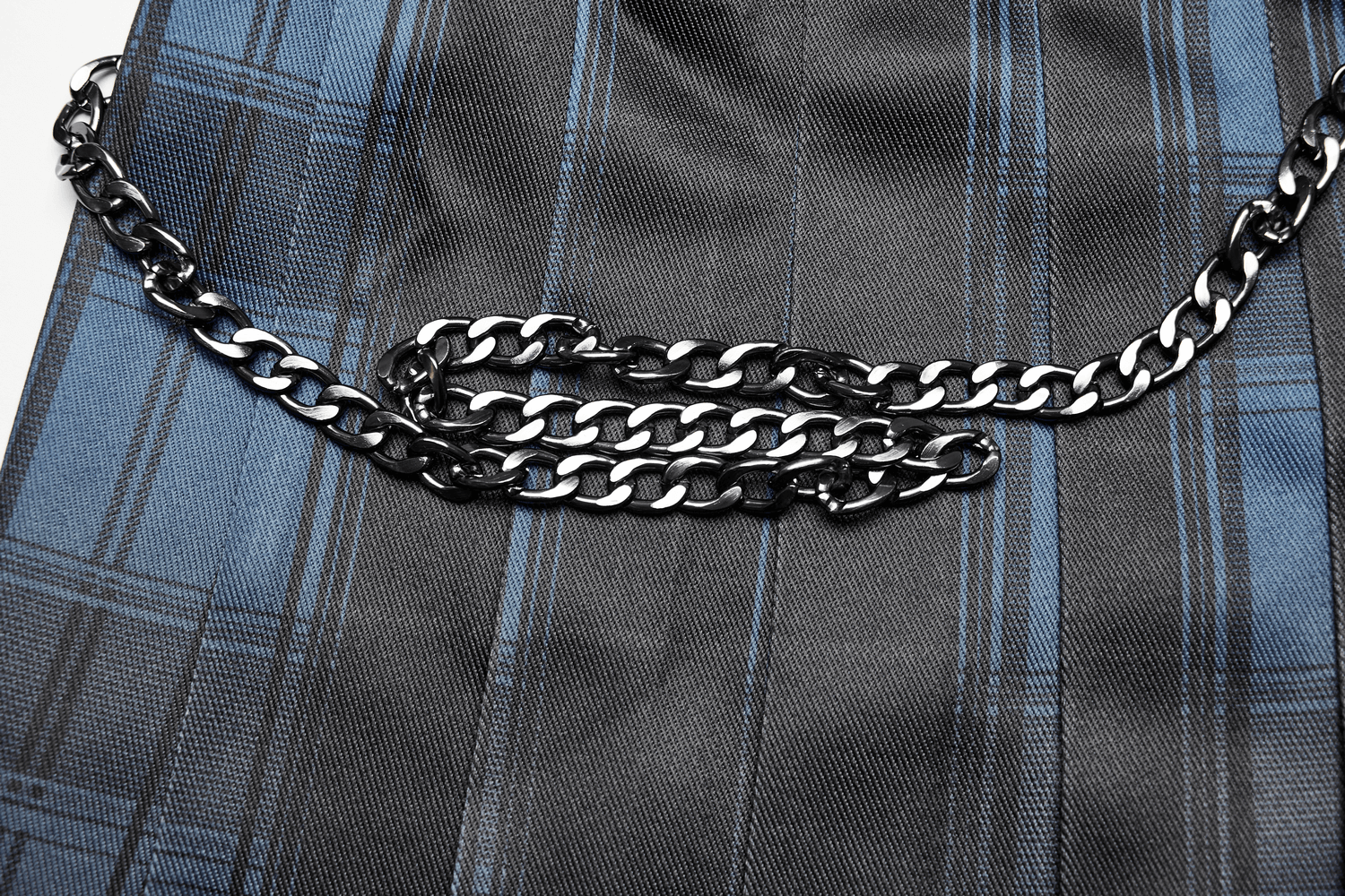 Close-up of a gradient Scottish punk kilt featuring a stylish black metal chain detail on woven plaid fabric.