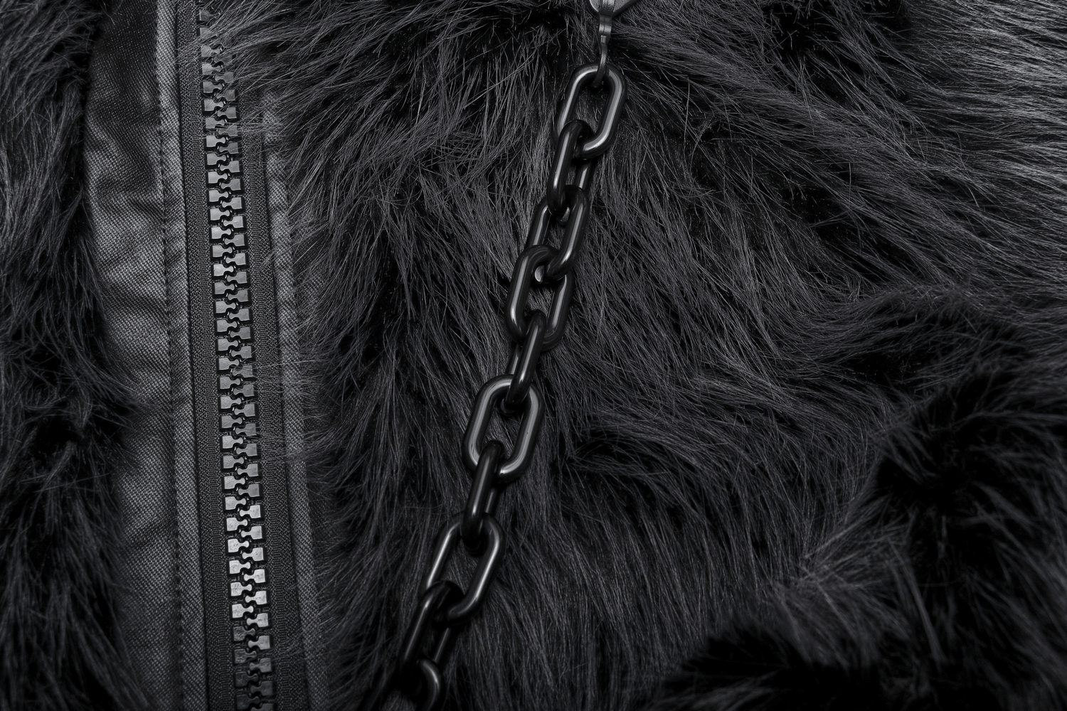 Close-up of gray faux fur jacket with removable black chain accent and zipper detailing for edgy style.