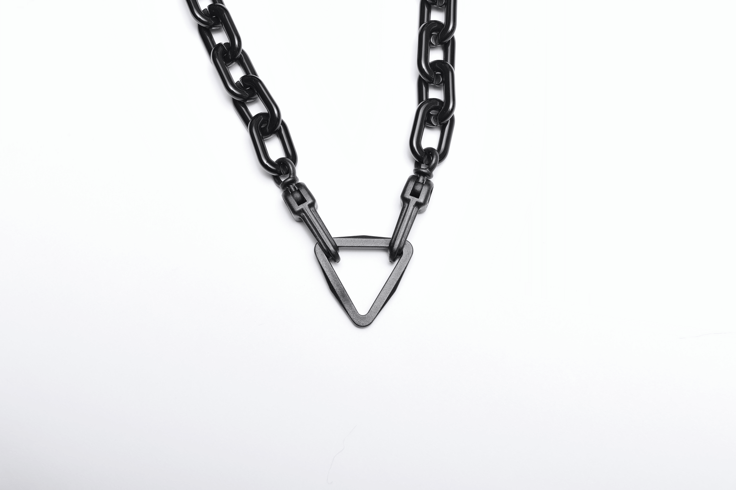 Bold black chain necklace with triangular accent for a striking fashion statement.