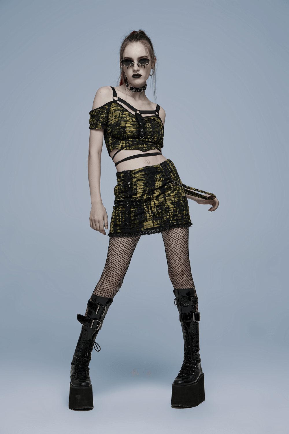 Gothic knit crop T-shirt with strap detail, paired with a matching skirt and bold platform boots.