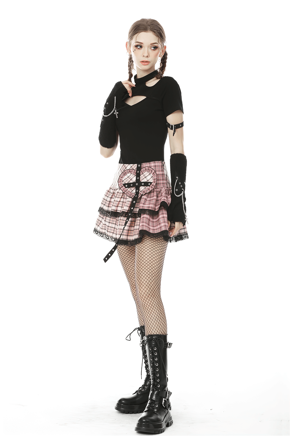 Edgy female model in pink and black plaid mini skirt, black top, and combat boots for punk rock fashion.