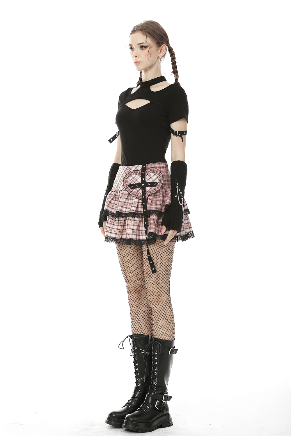 Grunge female model in pink and black plaid mini skirt and cut-out top, showcasing edgy punk style.