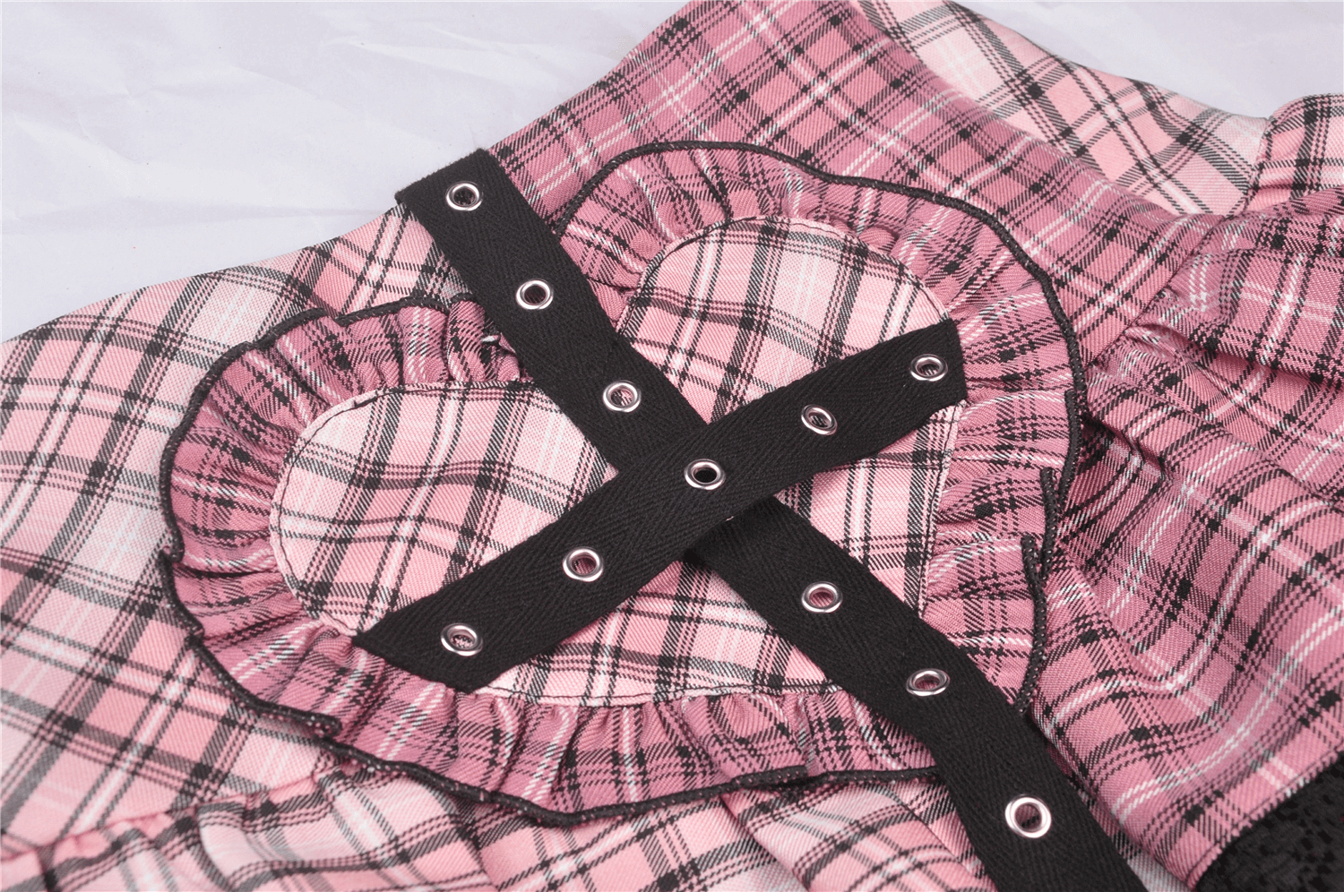 Pink and black plaid mini skirt with heart-shaped cutouts and black belt featuring grommets, perfect for punk rock fashion.