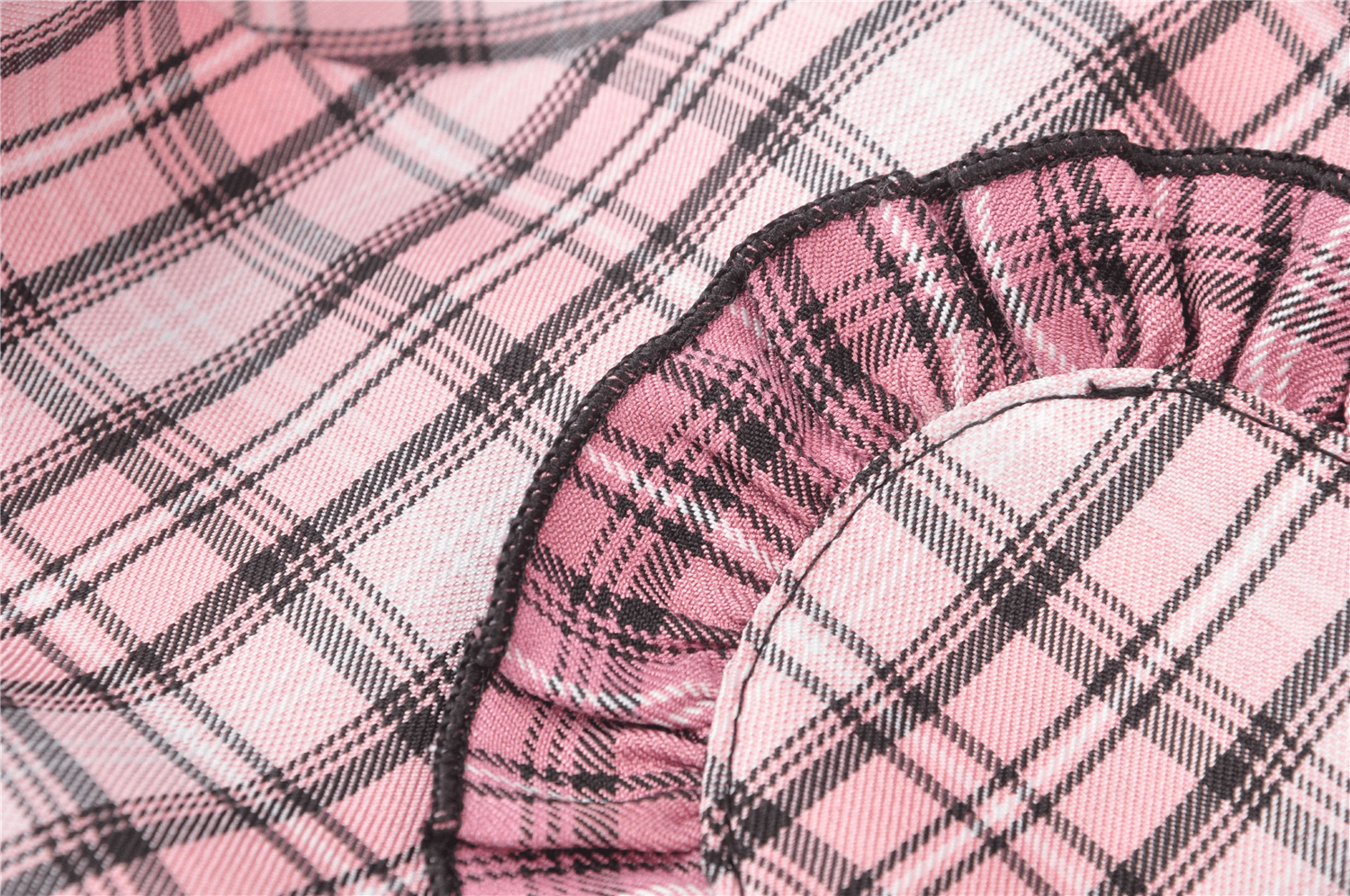 Close-up of pink and black plaid fabric with ruffled edges, perfect for an edgy mini skirt design.