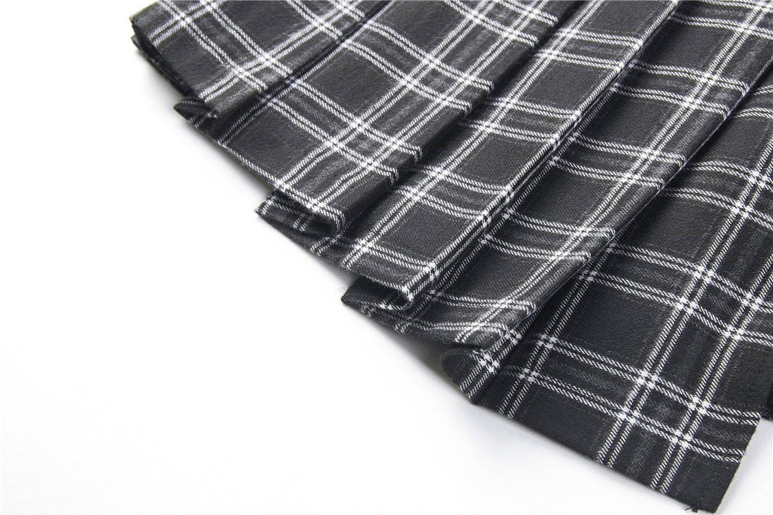 Asymmetrical black and white plaid skirt folds showcasing edgy punk style and soft fabric, perfect for rebellious outfits.