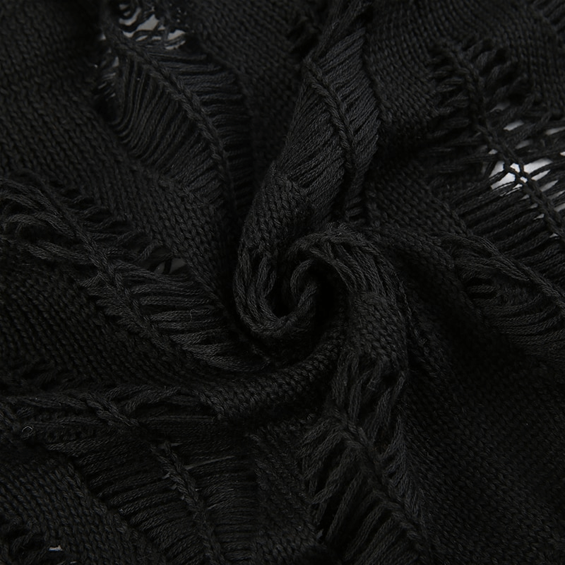 Close-up of black ripped fabric showcasing distressed details of a vintage grunge pullover.