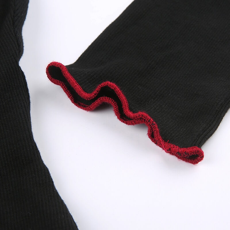 Close-up of black long-sleeve top with red ruffled cuffs, perfect for grunge and gothic fashion styles.