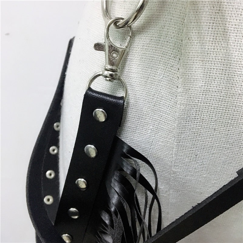 Close-up of black leather crop top with stainless steel clips and studs, perfect for goth and rave outfits.