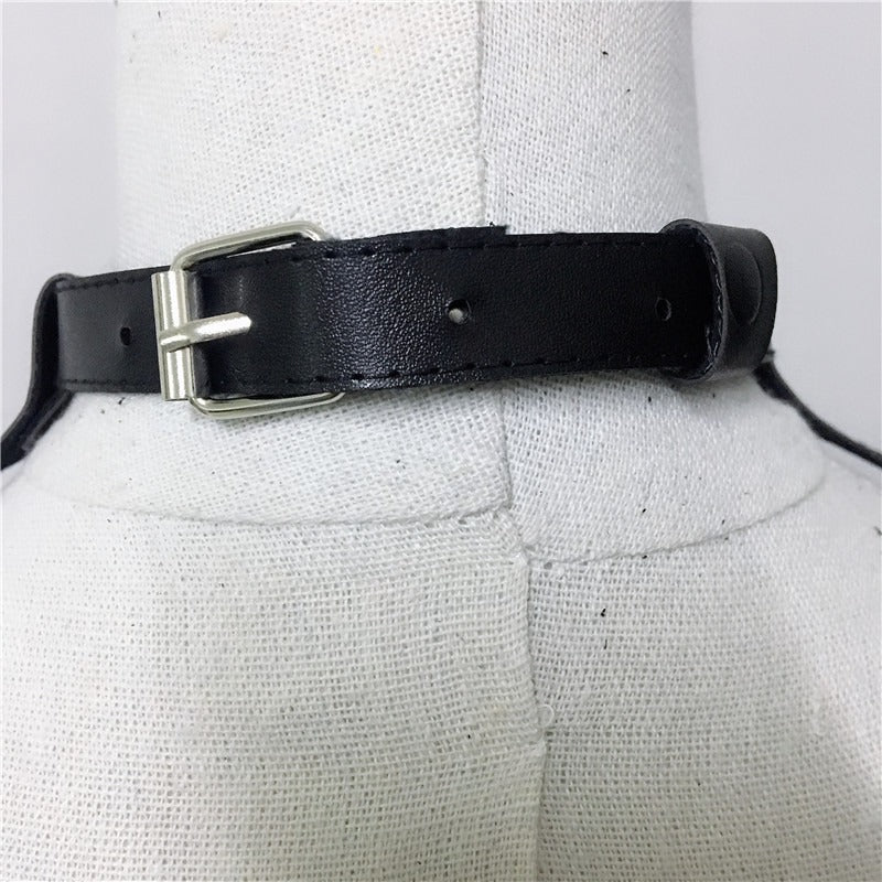 Close-up of a black leather strap with a silver buckle on a mannequin for alternative fashion styling.