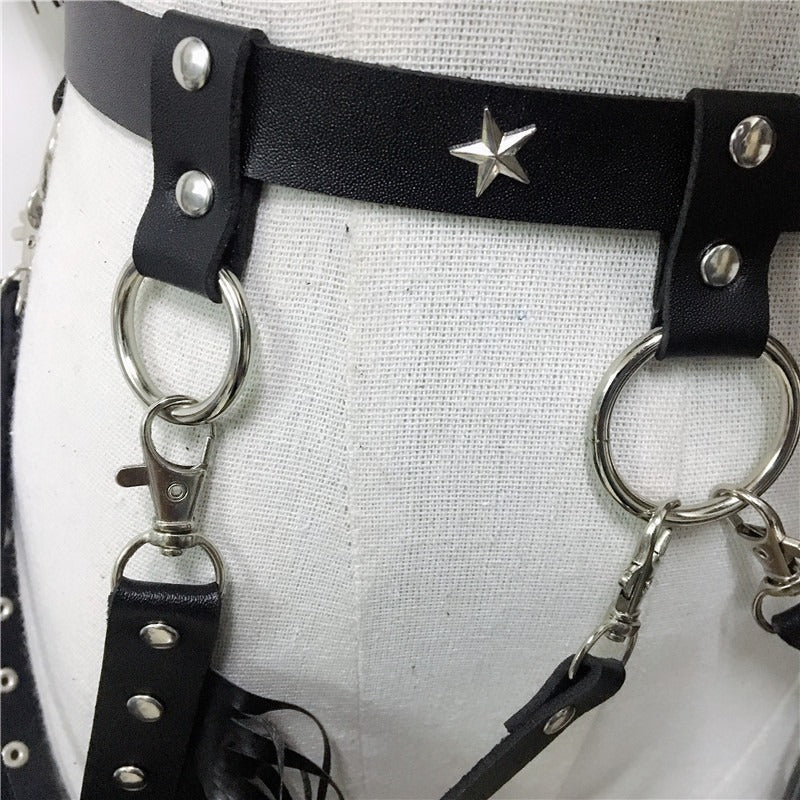 Close-up of black leather belt with silver star and metal rings, perfect for gothic and rave outfits.
