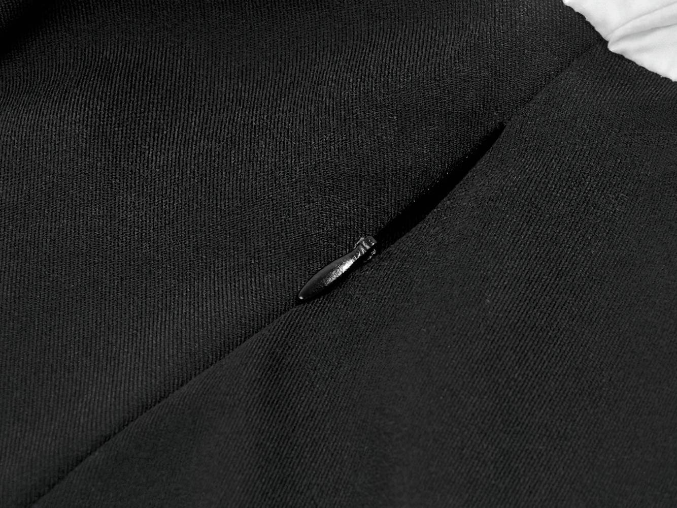 Close-up of the zipper detail on the Harlequin Black and White Gothic Ruffle Mini Dress.