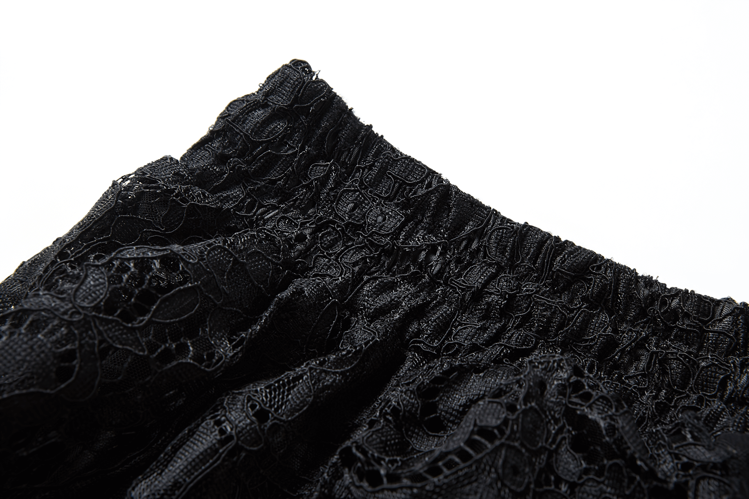 Close-up of the waistband of a black lace maxi skirt, showcasing intricate floral lace texture and elastic detail.