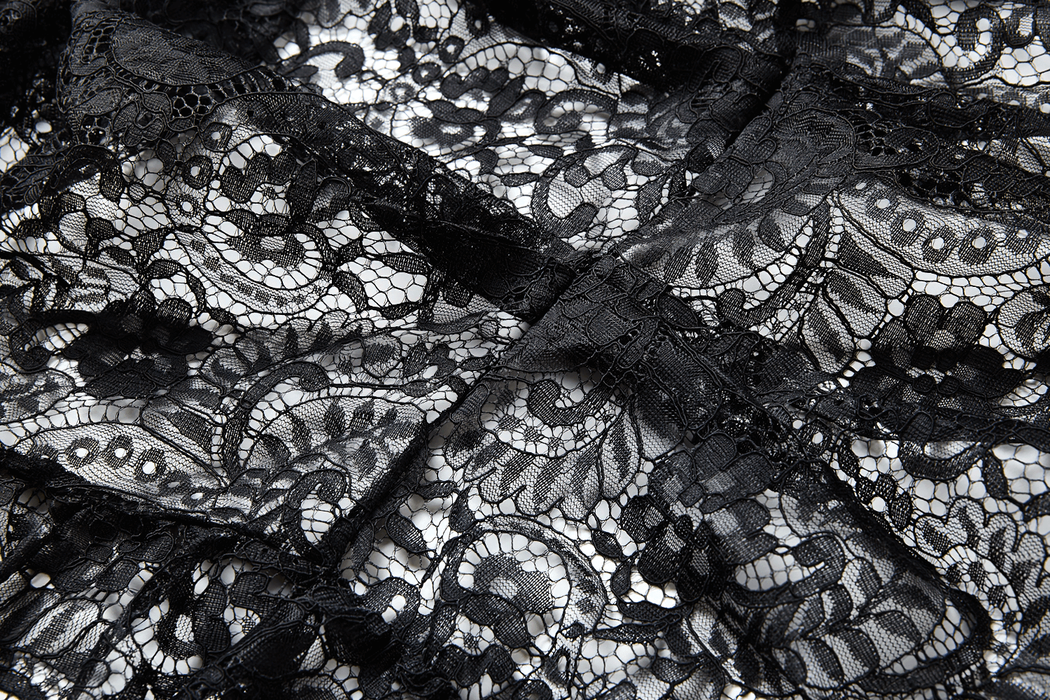 Close-up of intricate black lace details showcasing floral patterns and textures for a dramatic look.