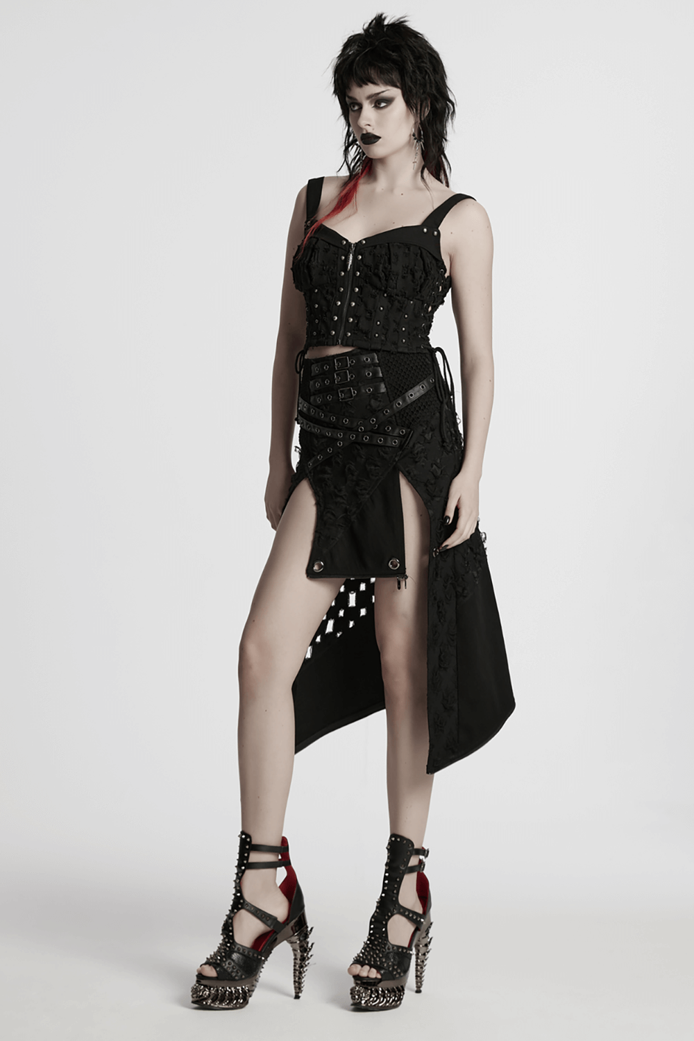 Model showcases a high slit punk detachable skirt with faux leather accents, styled with edgy heels.