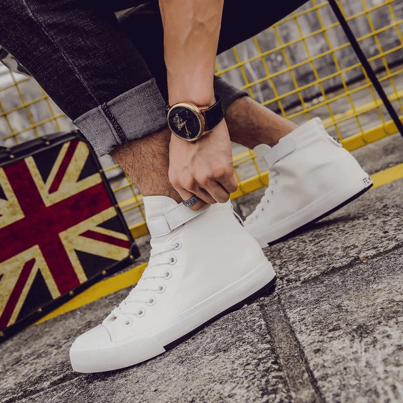White high top sneakers for women being laced up, stylishly paired with jeans and a watch, perfect for rock outfits.