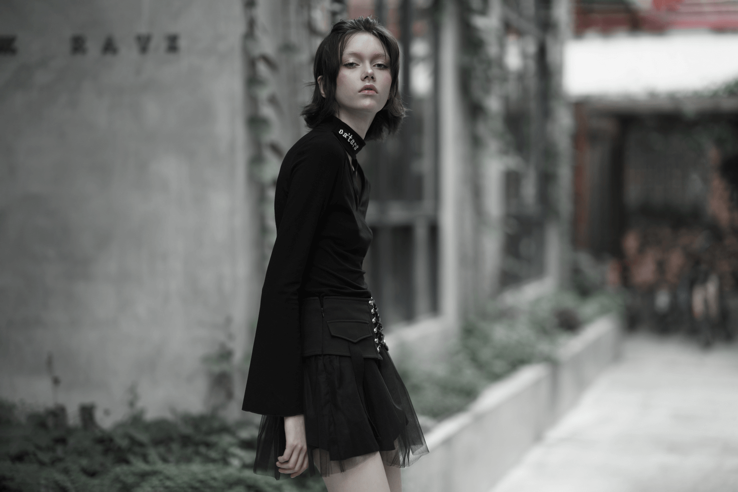 Model showcasing a high-waist black gothic skirt with lace-up detail in an urban setting, exuding punk style.