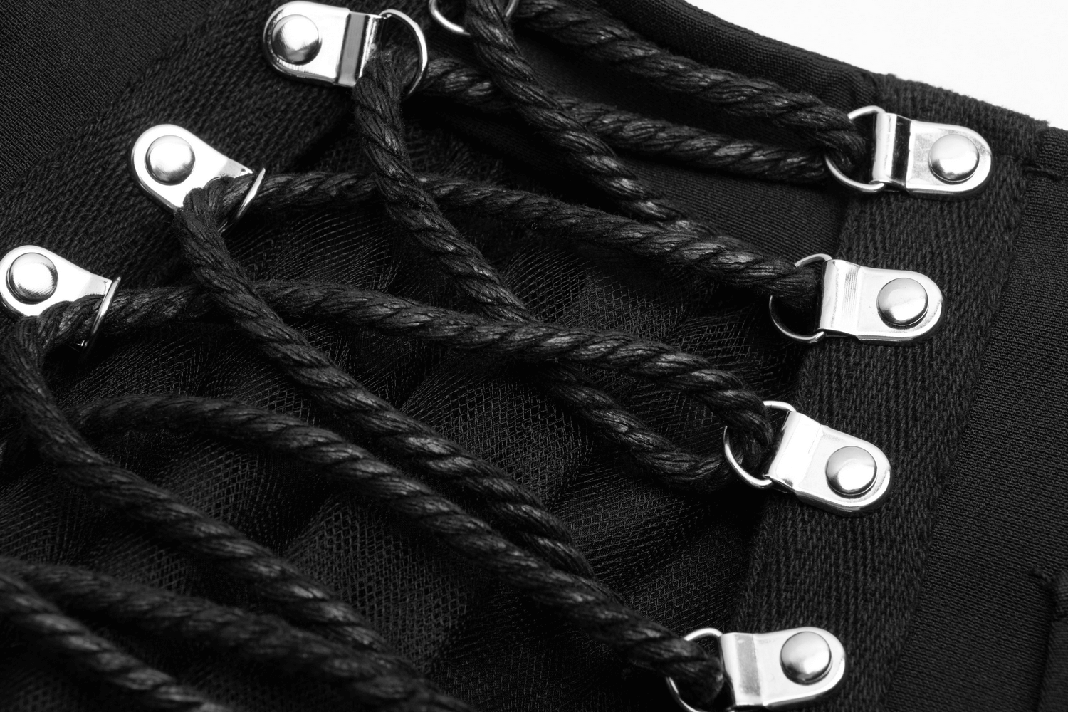 Close-up of lace-up detail on a high-waist black gothic skirt showcasing punk style elegance.